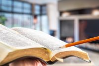 Bible with a pencil, against the background of the living room.