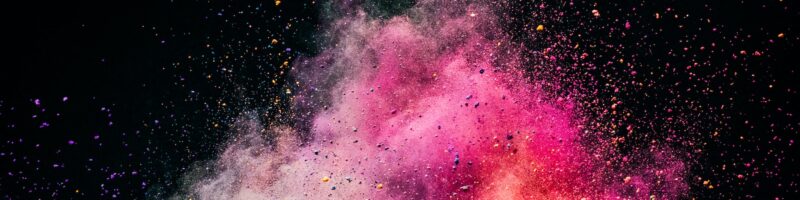 Holi powder exploding on black background.