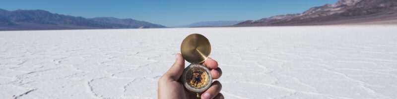 USA, California, Death Valley, man's hand holding compass