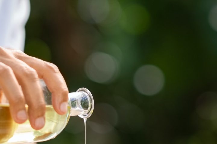 Masseuse hands pouring massage oil