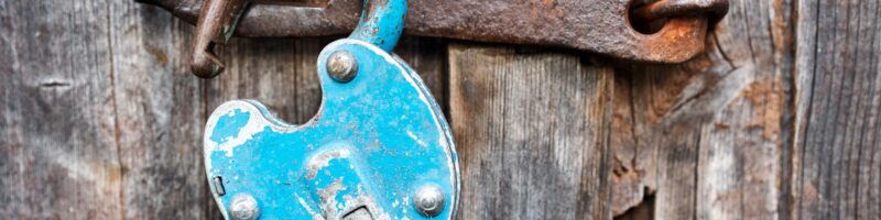 Blue old rusty unlocked padlock on wooden door