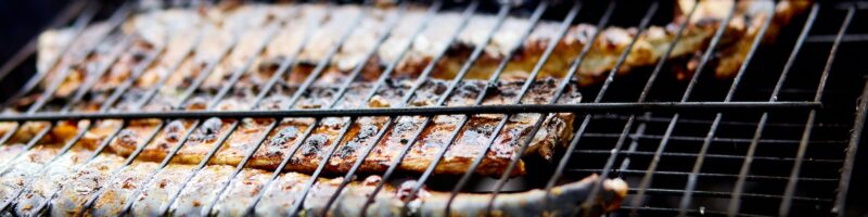Grilled fish mackerel, cooked on the grill in the open air flow