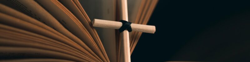 Homemade cross on an open Holy Bible book. Cross in open Bible.