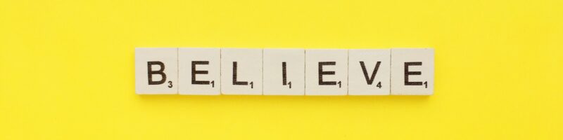 Believe scrabble letters word on a yellow background
