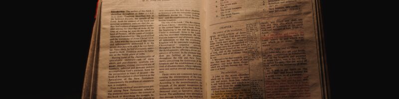 Old Bible book open on the book of Revelation