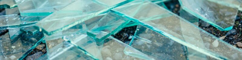 a small pile of broken glass lying on the asphalt