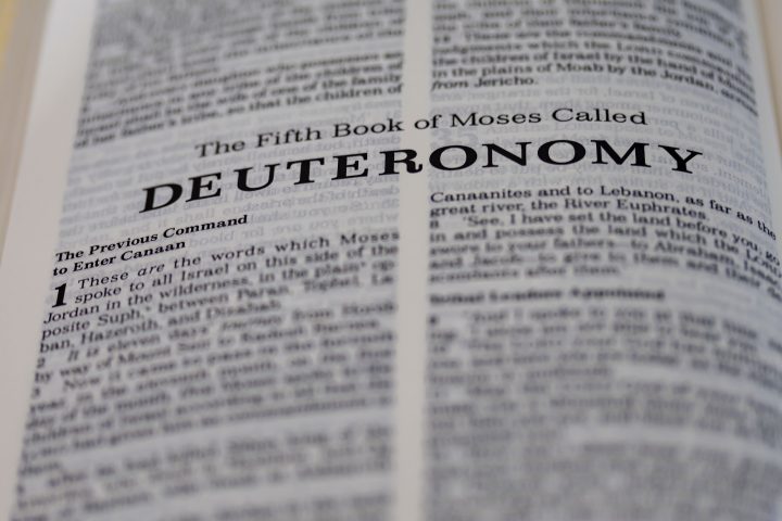 Closeup shot of open page with the fifth book of moses called deuteronomy text