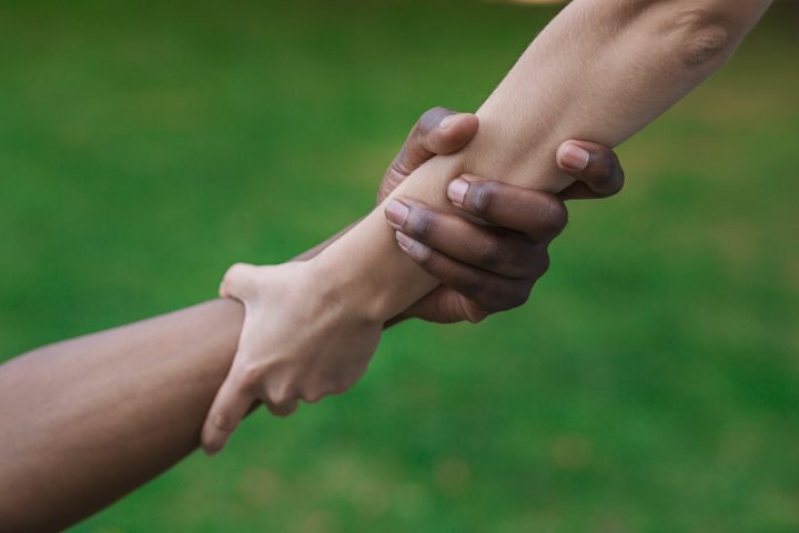 Multiethnic friends helping hand outdoor, copy space