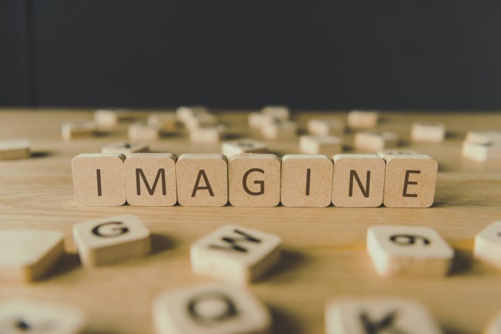 selective focus of word imagine made of cubes surrounded by blocks with letters on wooden surface