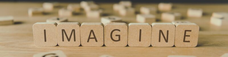 selective focus of word imagine made of cubes surrounded by blocks with letters on wooden surface