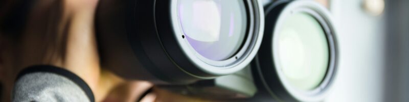Young Woman use of the binoculars for birdwatching