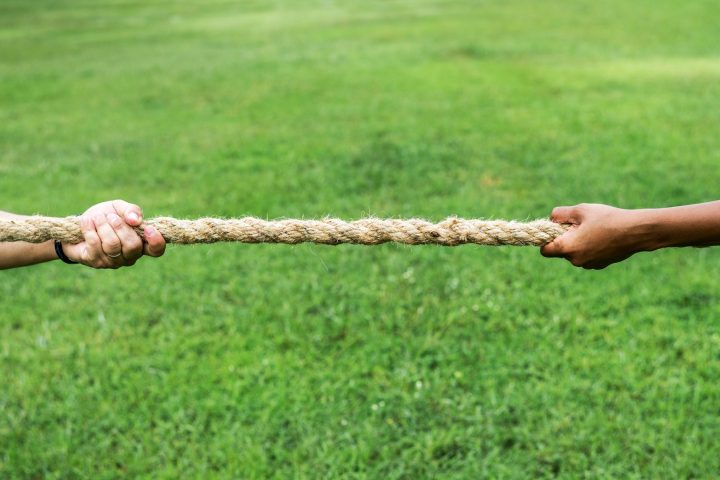 Closeup of hand pulling the rope in tug of war game