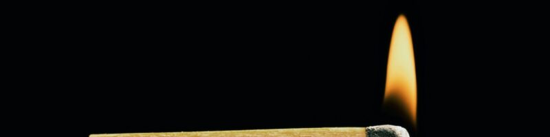 Burning match on a black background