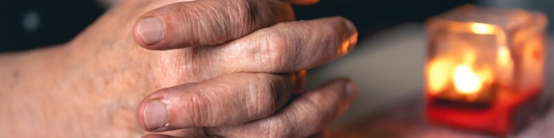Hands of an old woman folded for prayer.
